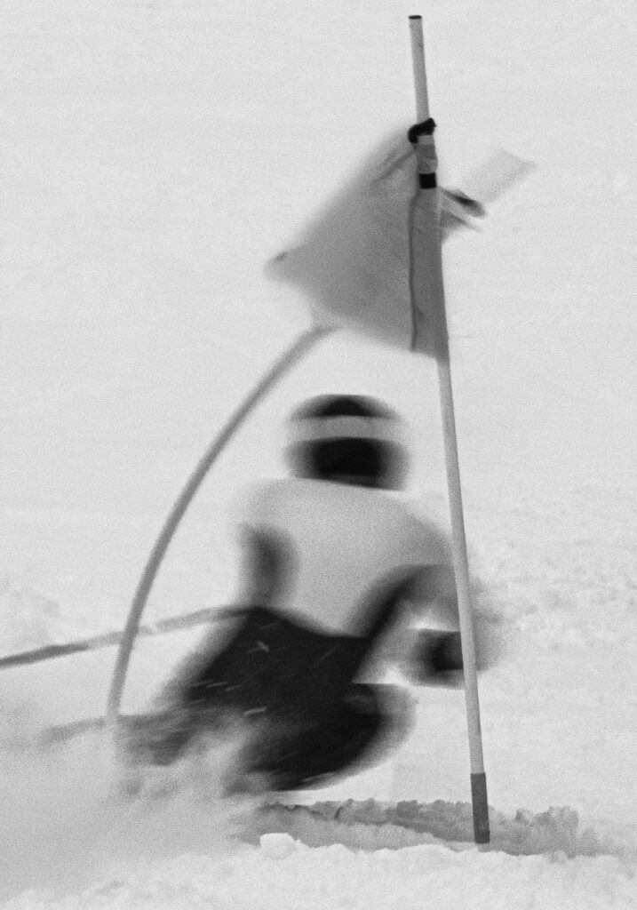 A person skiing downhill fast.