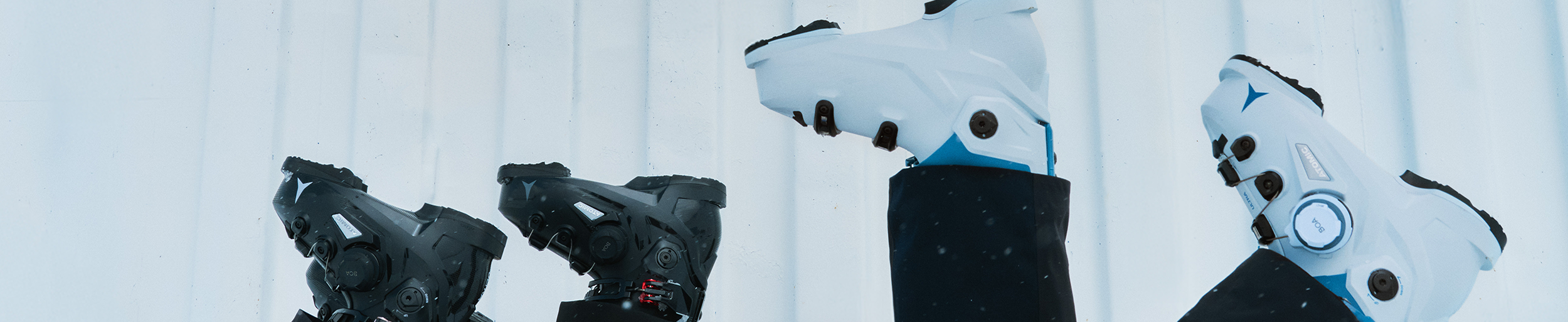 Two pairs of Atomic boots in the air