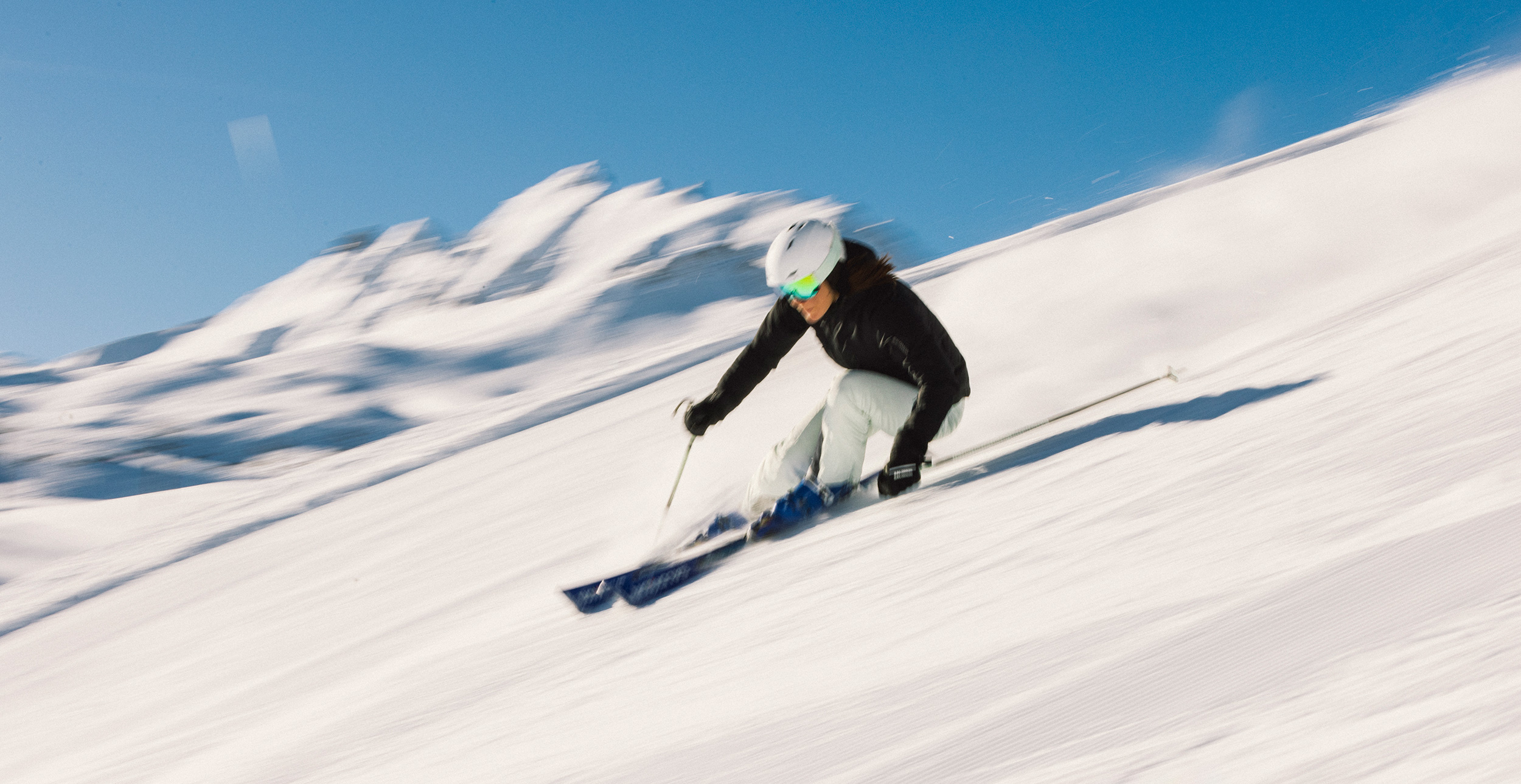 A person skiing downhill fast.