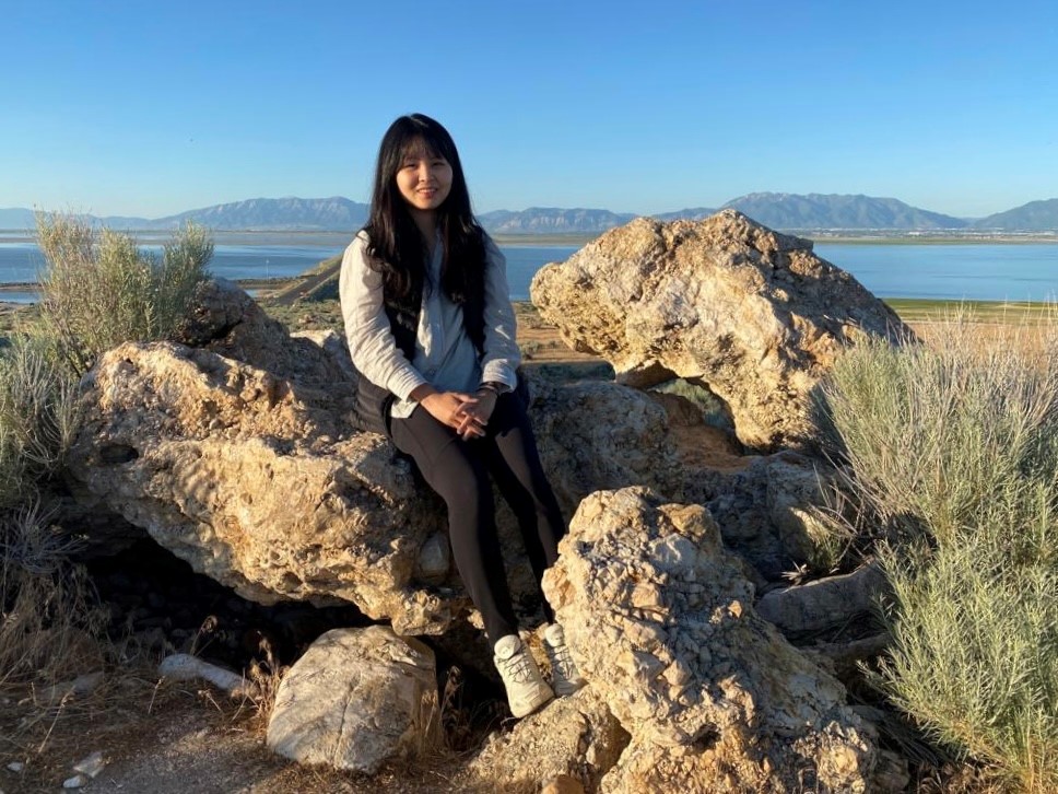 Olivia sitting on a rock while out hiking.