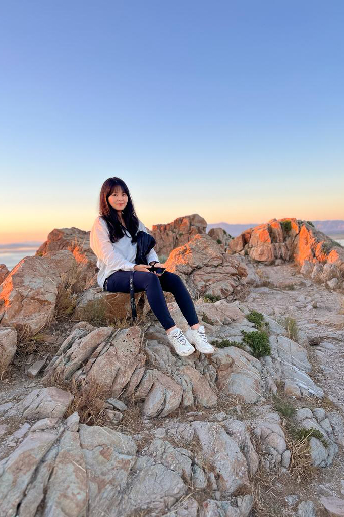 Profile picture of Olivia Cho sitting on top of a mountain.