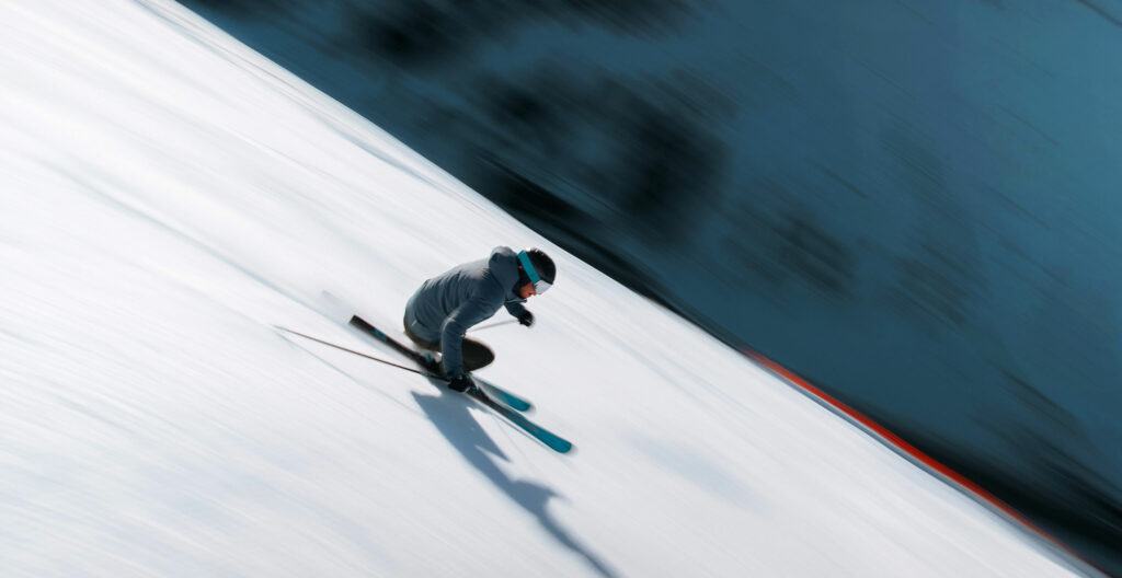 An alpine skier is going down the slope on Atomic skis