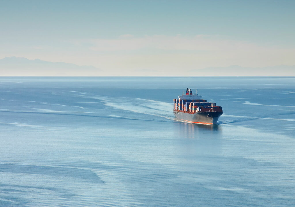 Cargo ship loaded with containers sailing on the sea.