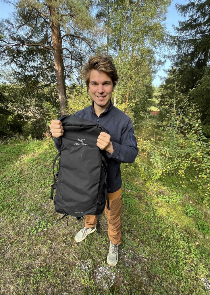 Antti-Jussi holding an Arc'teryx backpack in the outdoors.