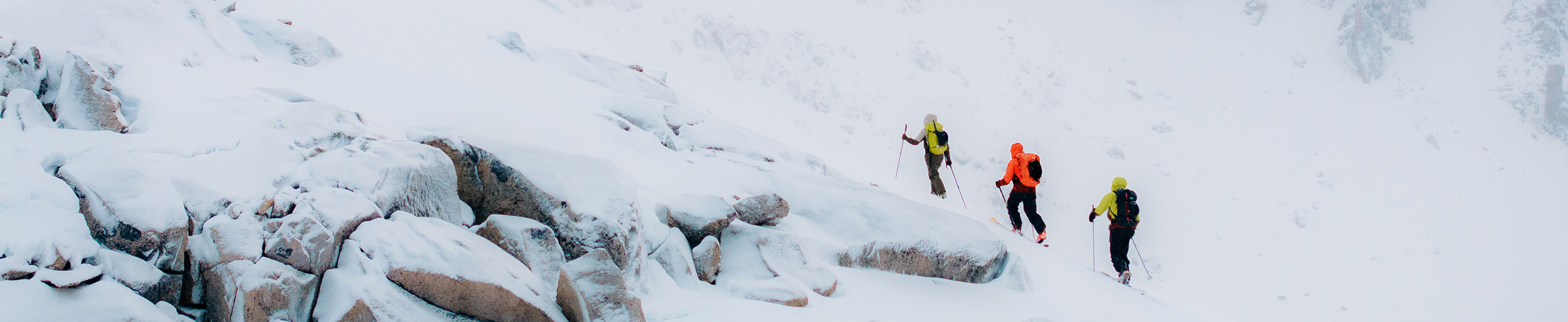 Three people hiking in snowy mountains.