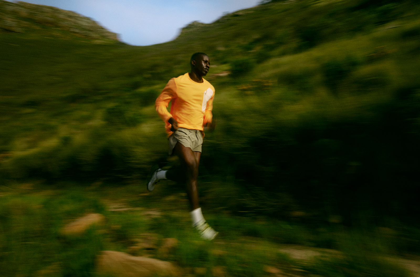 A person running on a green hill.