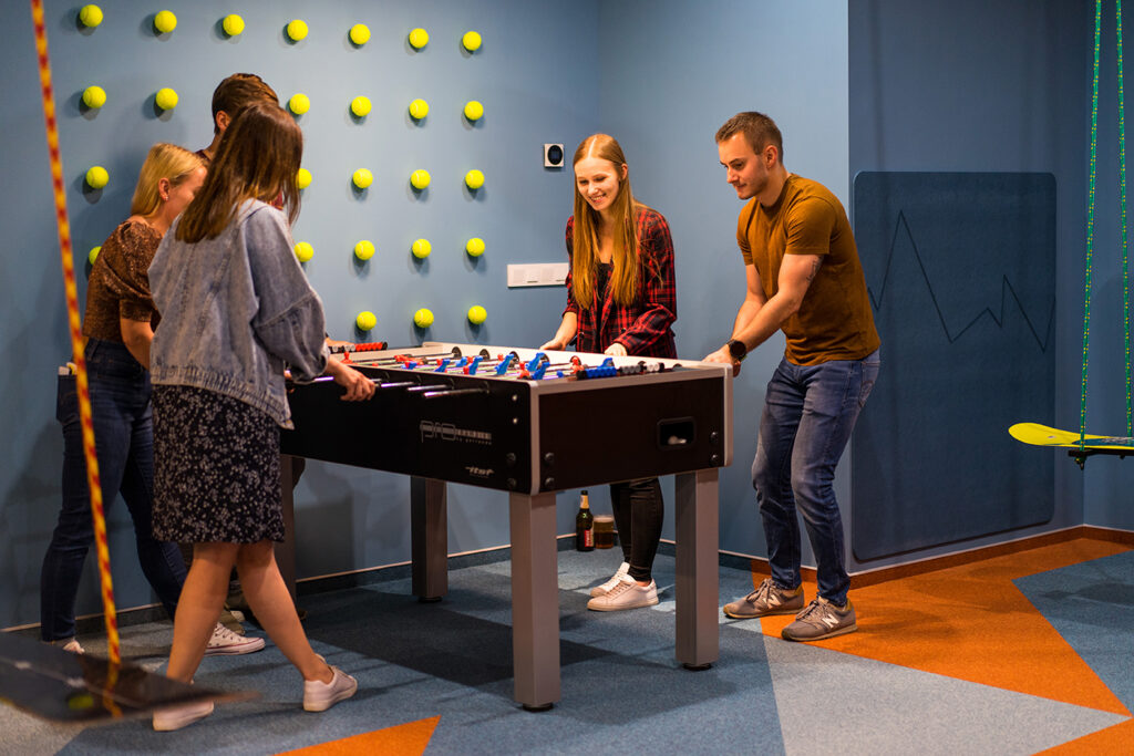 A group of people playing table football in an office