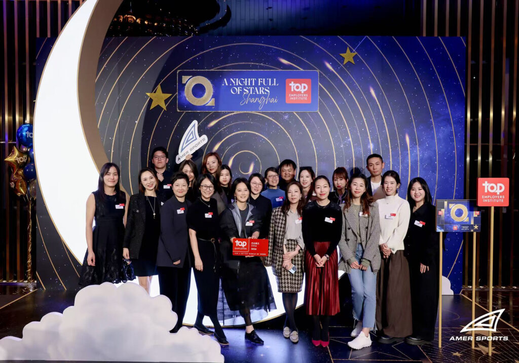 Amer Sports team celebrating Top Employer award at a night‑themed company event in Shanghai