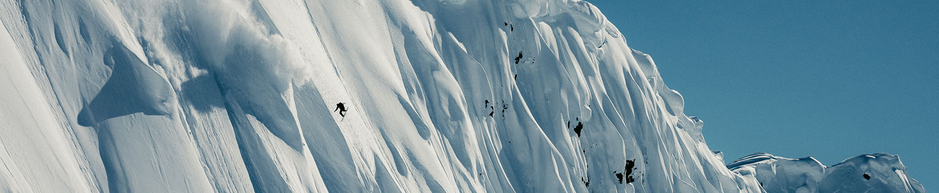 Snowboarder on snowy mountains in Alaska.
