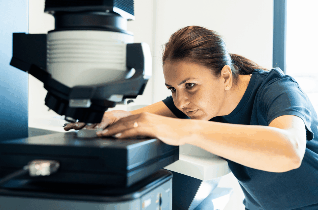 Amer Sports employee carefully positioning a sample under a precision microscope.